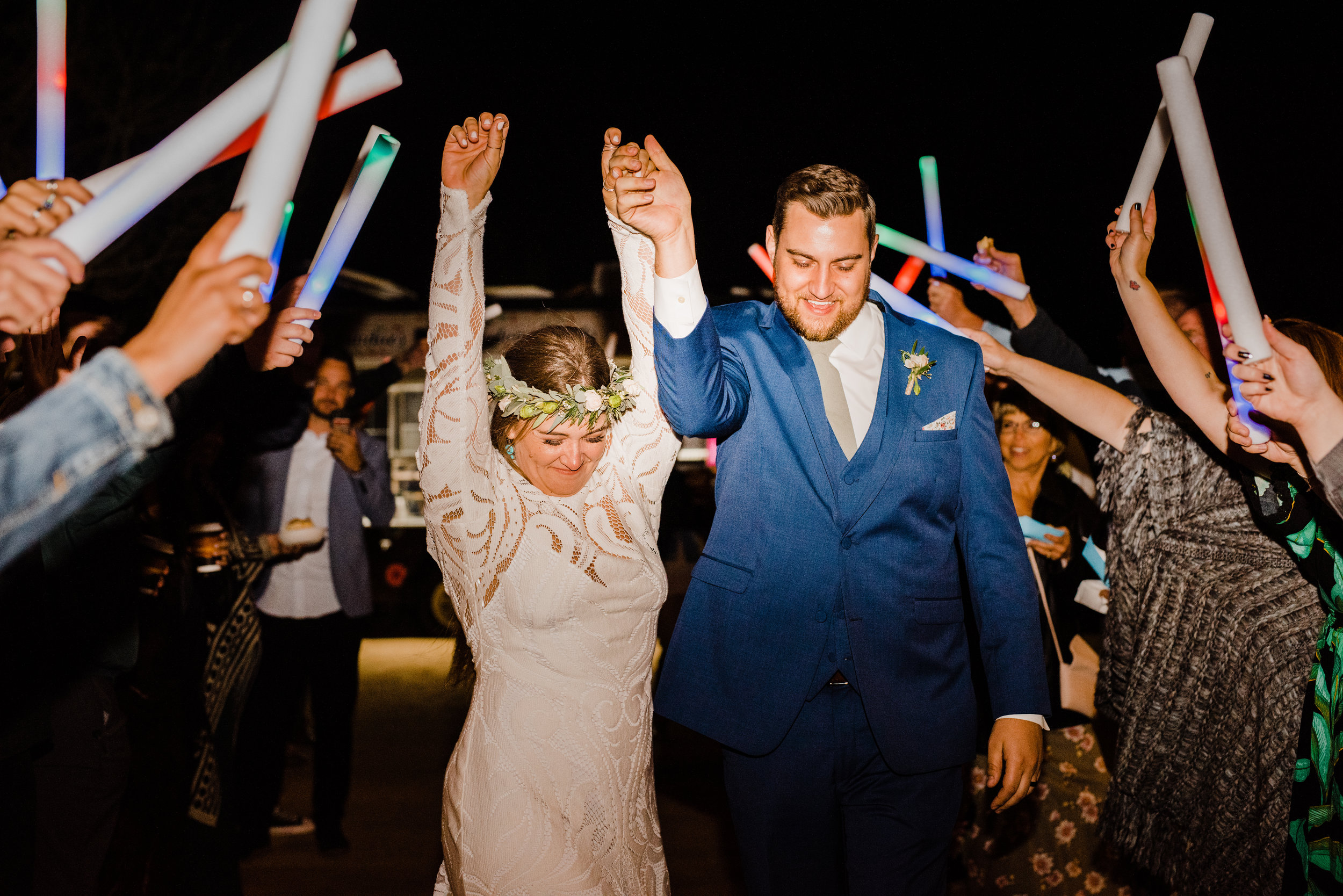 Bride cheers during glowstick wedding reception exit