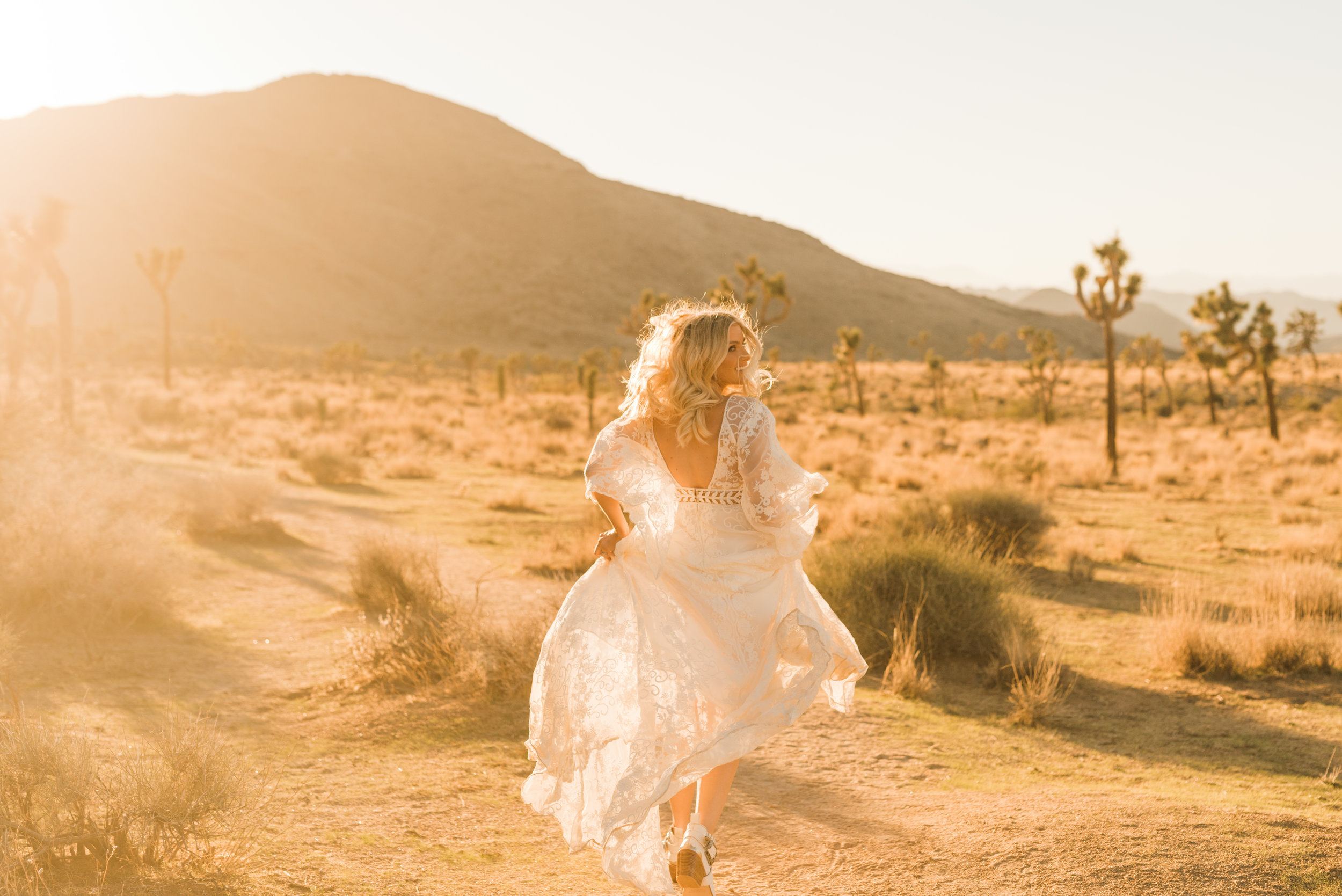 Bride in ankle boots and Rue De Seine runs during golden hour in Joshua Tree National Park in Rue De Seine boho lace dress