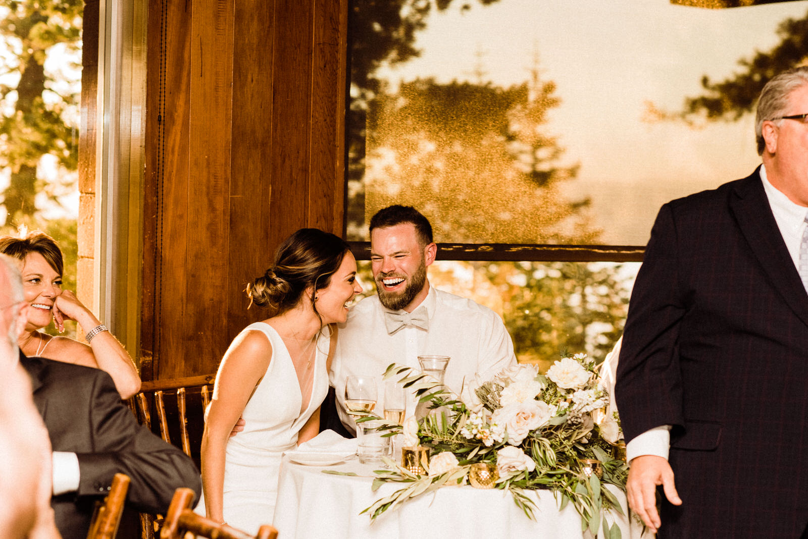 Couple laughs during toasts at golden hour in Heavenly Lakeview Lodge in South Lake Tahoe