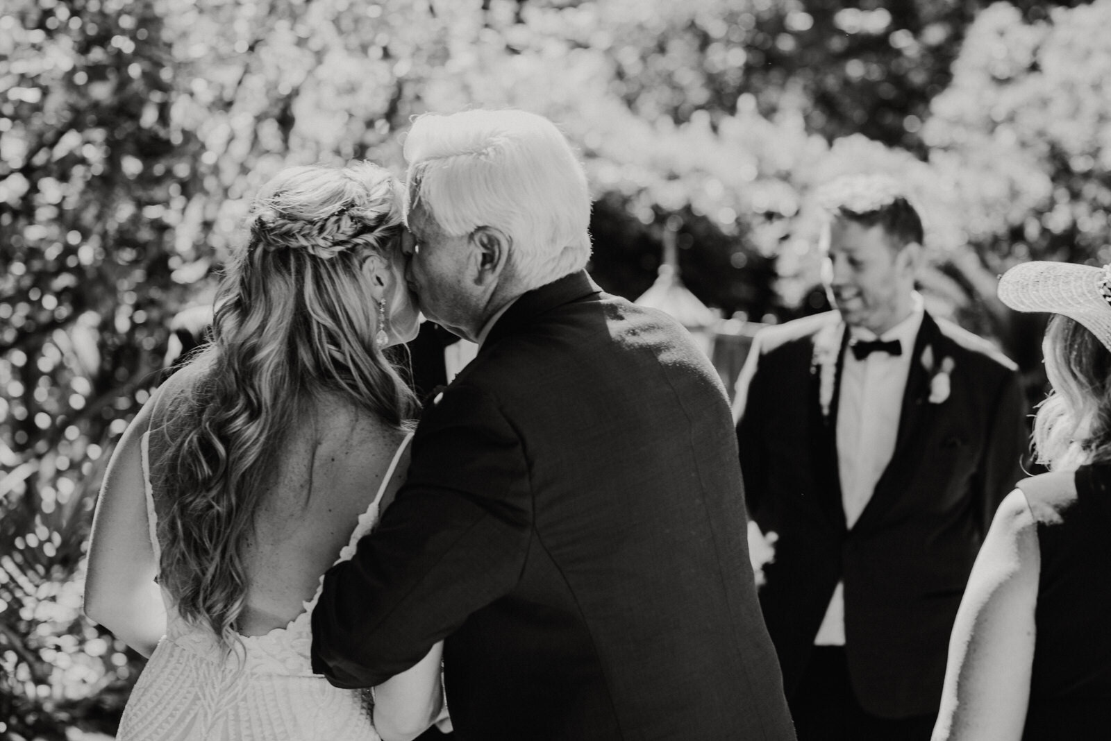 Dad kisses bride's cheek at ceremony on Houdini Estate Mosaic Driveway