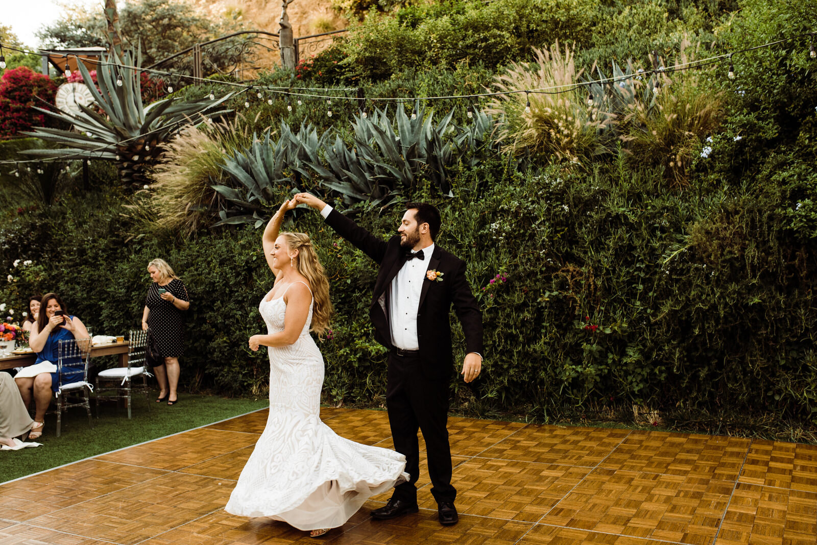 Groom in black tux spins bride at Summer Houdini Estate Wedding in Los Angeles | photo by Kept Record | www.keptrecord.com