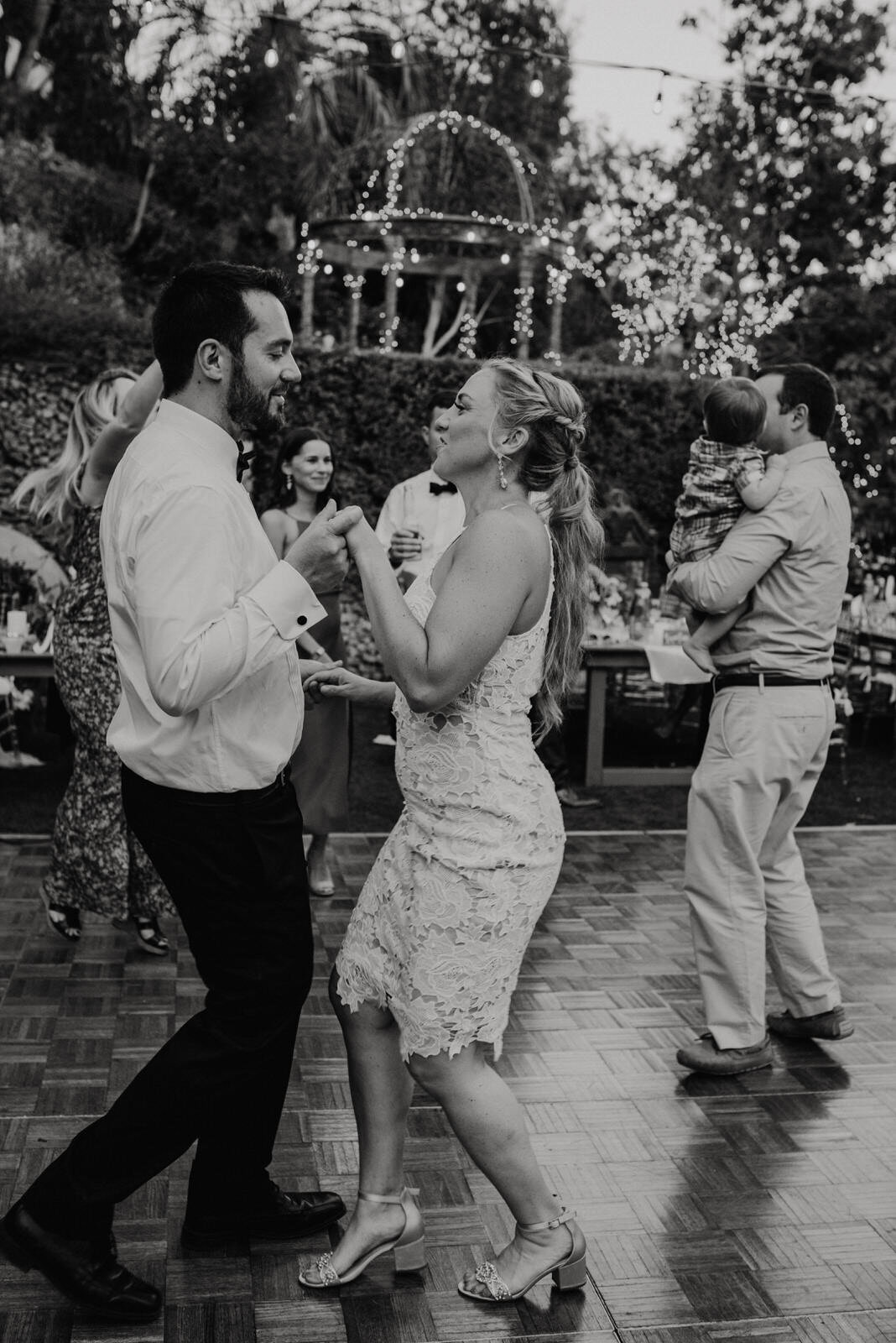 Black and white photo of Bride and Groom dancing at Summer Houdini Estate Wedding | Short Casual Lulu's Wedding Reception Dress | photo by Kept Record | www.keptrecord.com