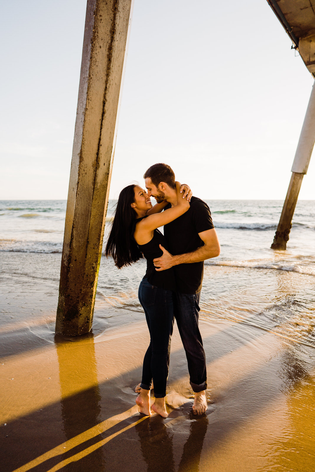 Romantic engagement photos beneath Hermosa beach pier