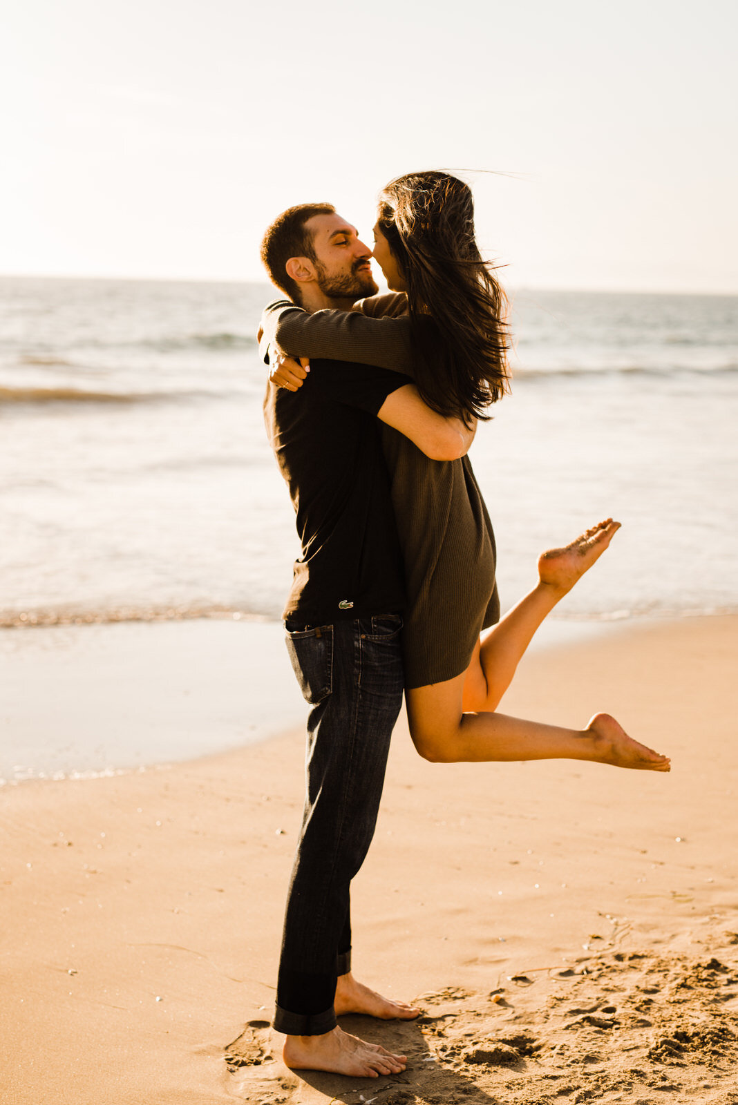 photo of man picking woman in green dress up at Hermosa Beach