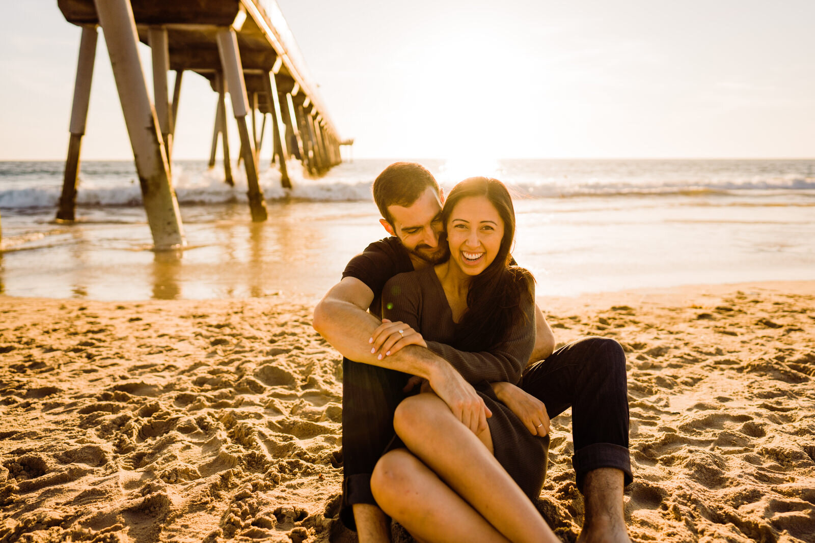 Couple sitting in the sand engagement photos at Hermosa beach