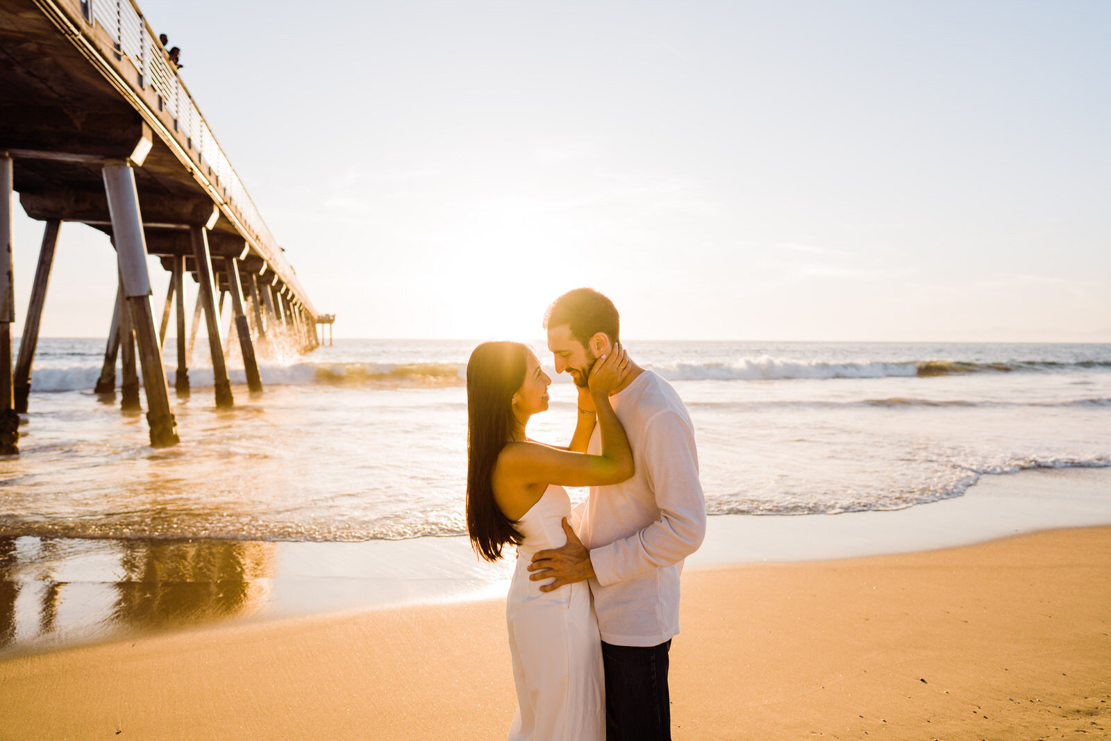 Matching engaged couple in white at Hermosa Beach Pier