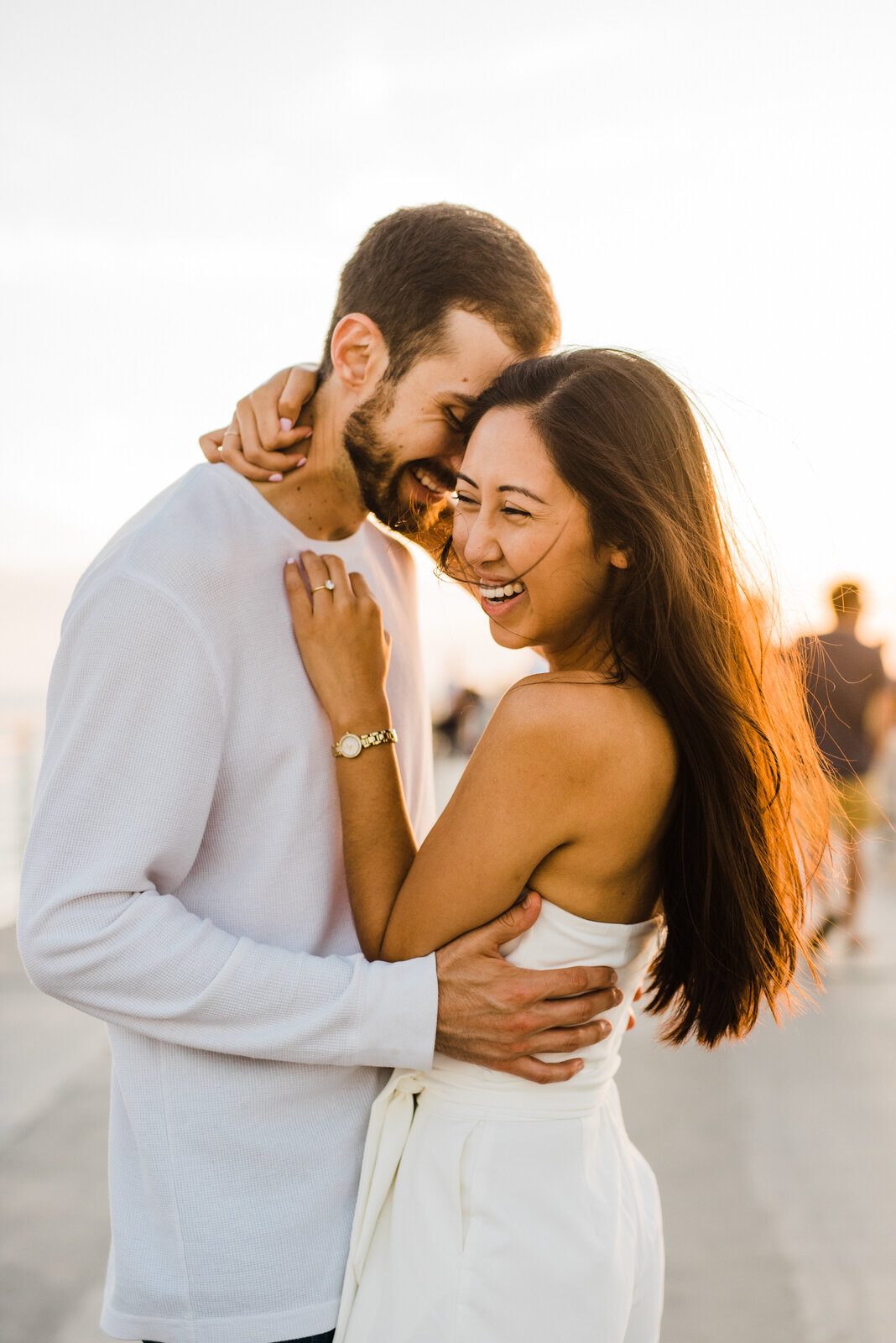 Couple laughing at Hermosa Beach pier engagement photos