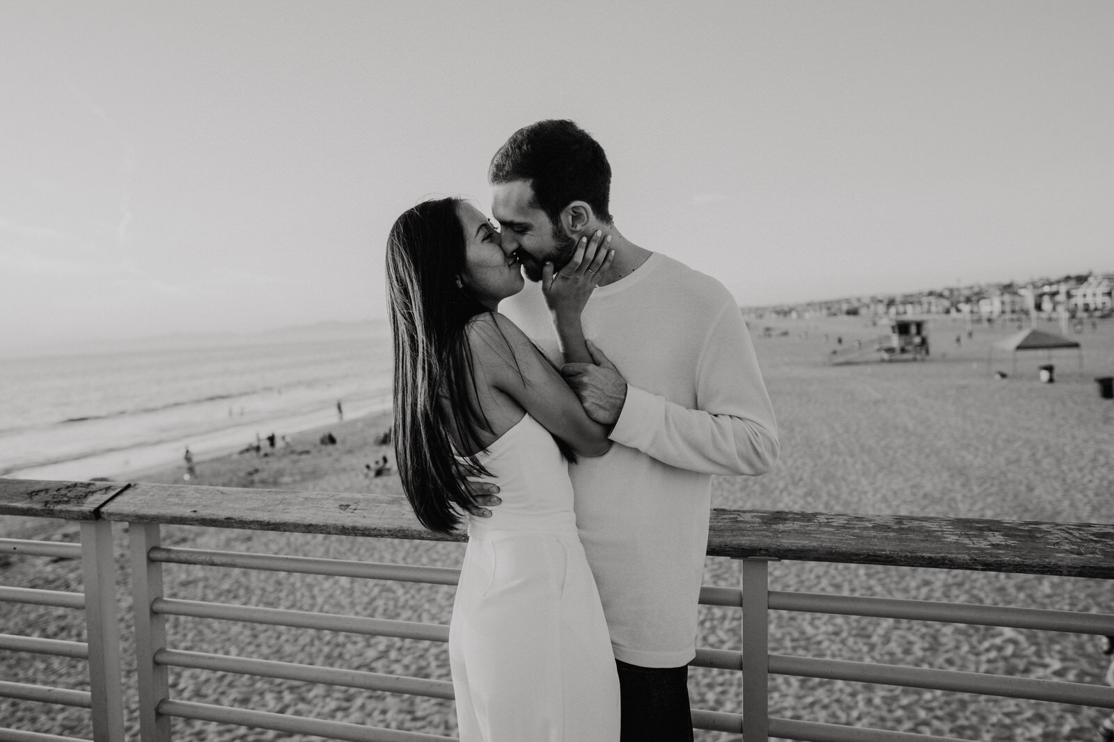 black and white romantic photo of couple kissing at Hermosa Beach Pier