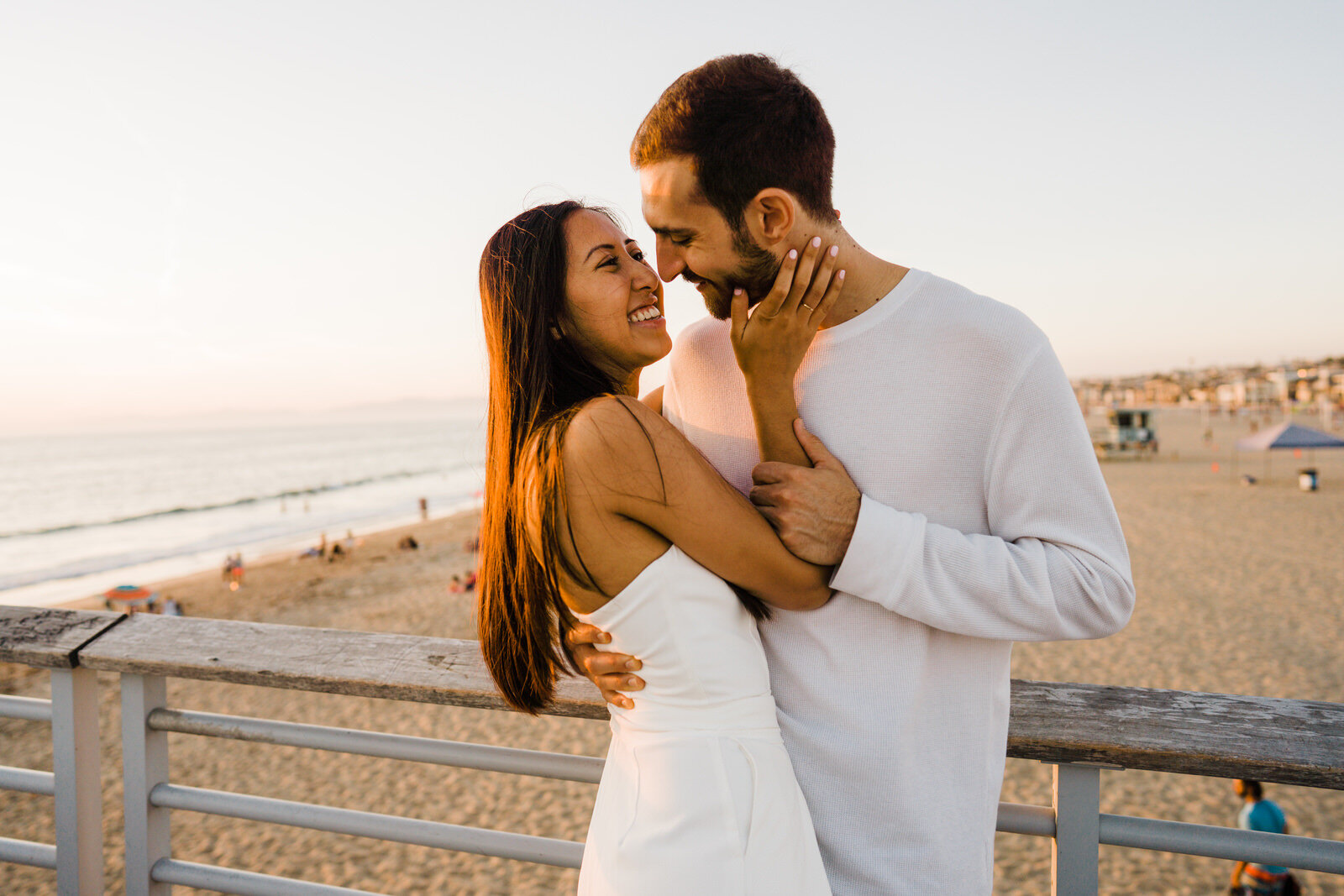 Couple embraces romantically at hermosa beach pier