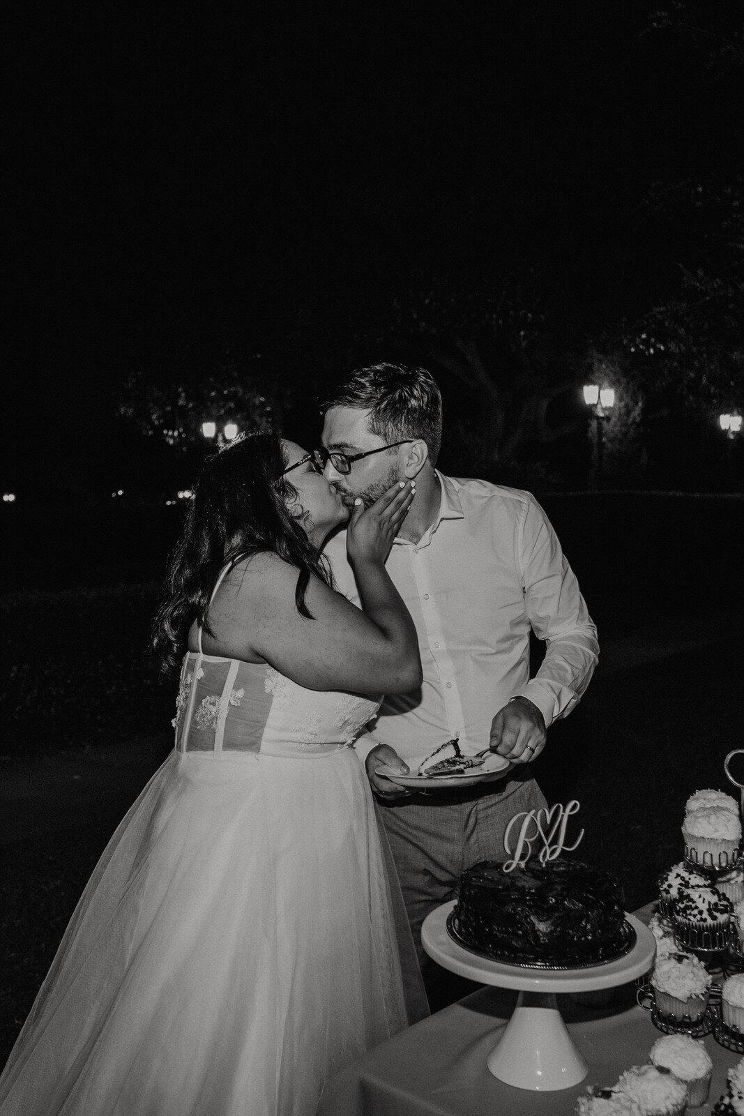 Bride and groom kiss with cake at Heritage Park in Santa Fe Springs