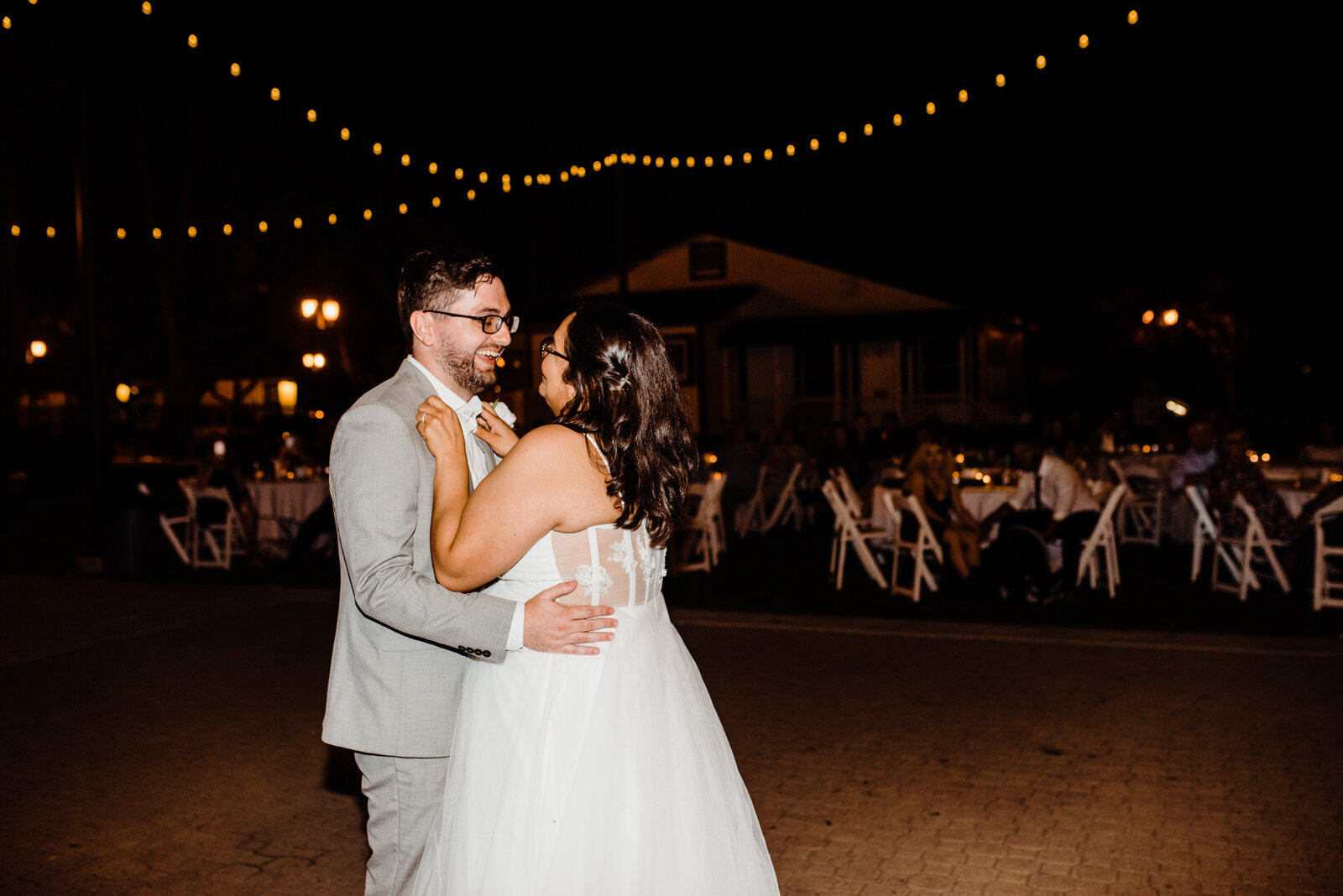 Reception space at Heritage Park lit by bistro lights on a summer wedding day