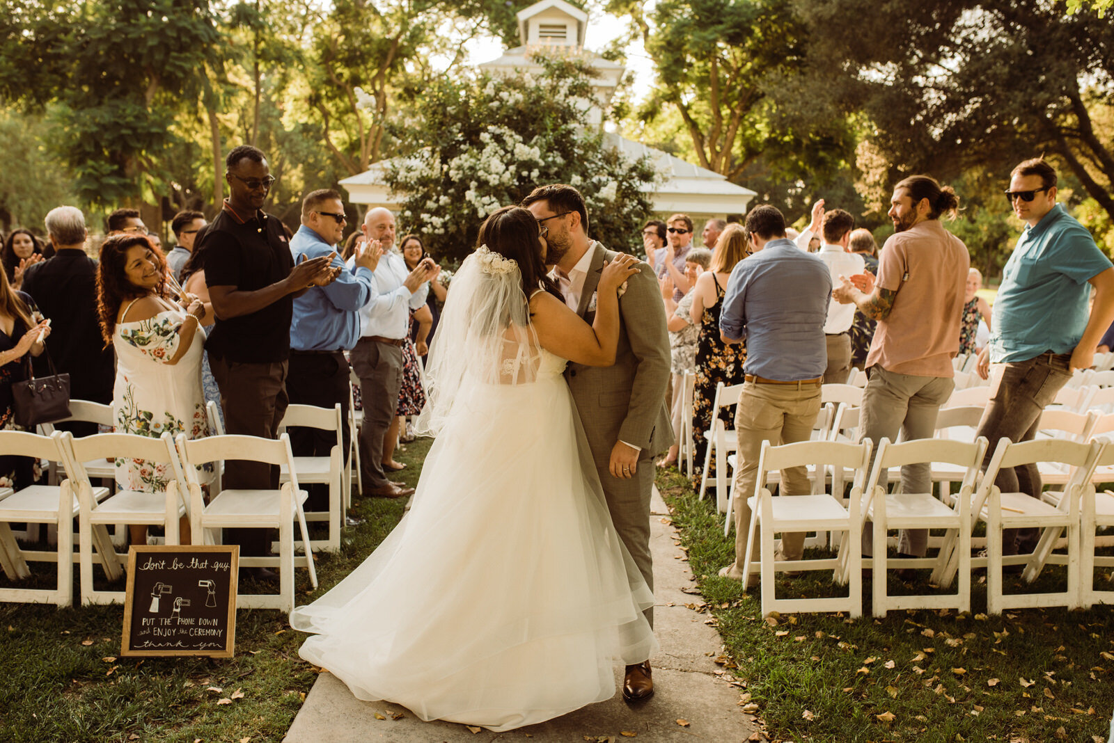 Couple kisses exiting ceremony at Heritage Park wedding in Santa Fe Springs