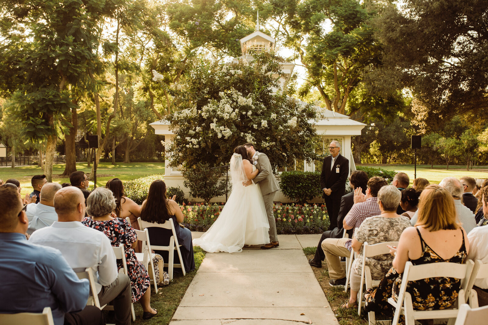 Couples first kiss in front of greenhouse at Heritage Park Wedding