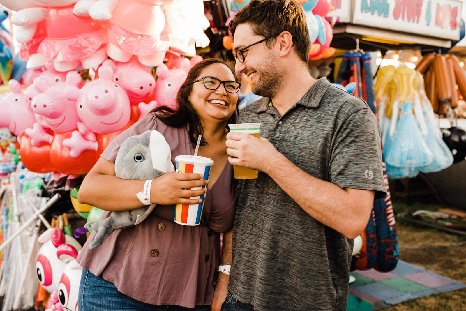 Orange county fair engagement photos with stuffed animals and beer