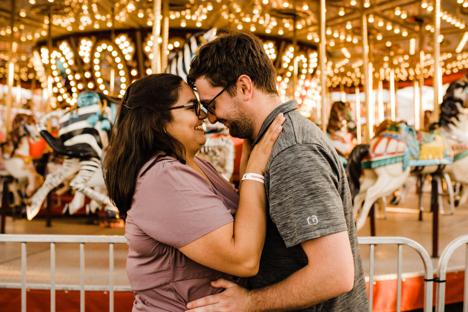Romantic engagement photos by carousel at Orange County Fair in Costa Mesa
