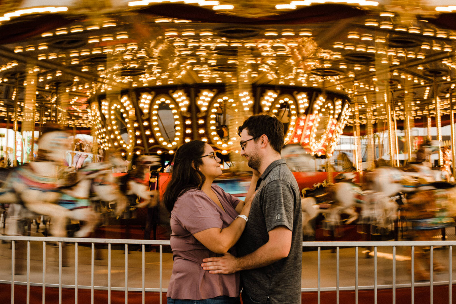 Engagement photos with blurry carousel spinning at OC Fair