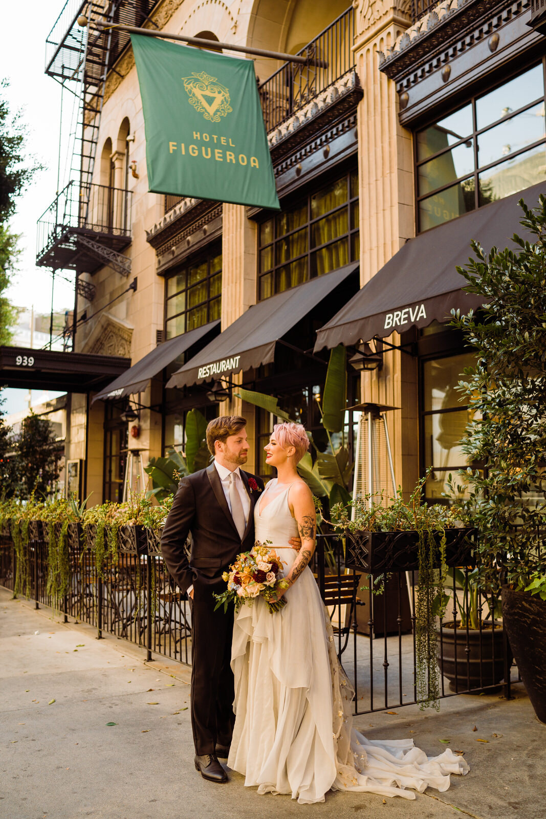 Newlywed photo in front of Hotel Figueroa facade at modern, feminist wedding
