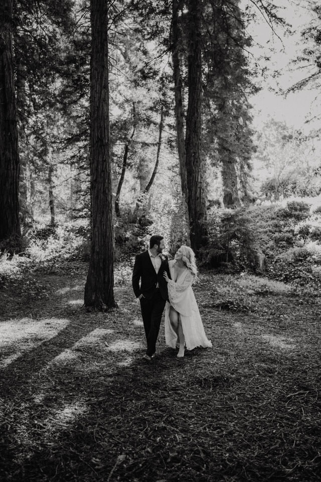Black and white photo of Boho eloping couple in the Redwoods, Bride wearing braided hairstyle and boho lace Bibiluxe wedding dress at San Francisco elopement