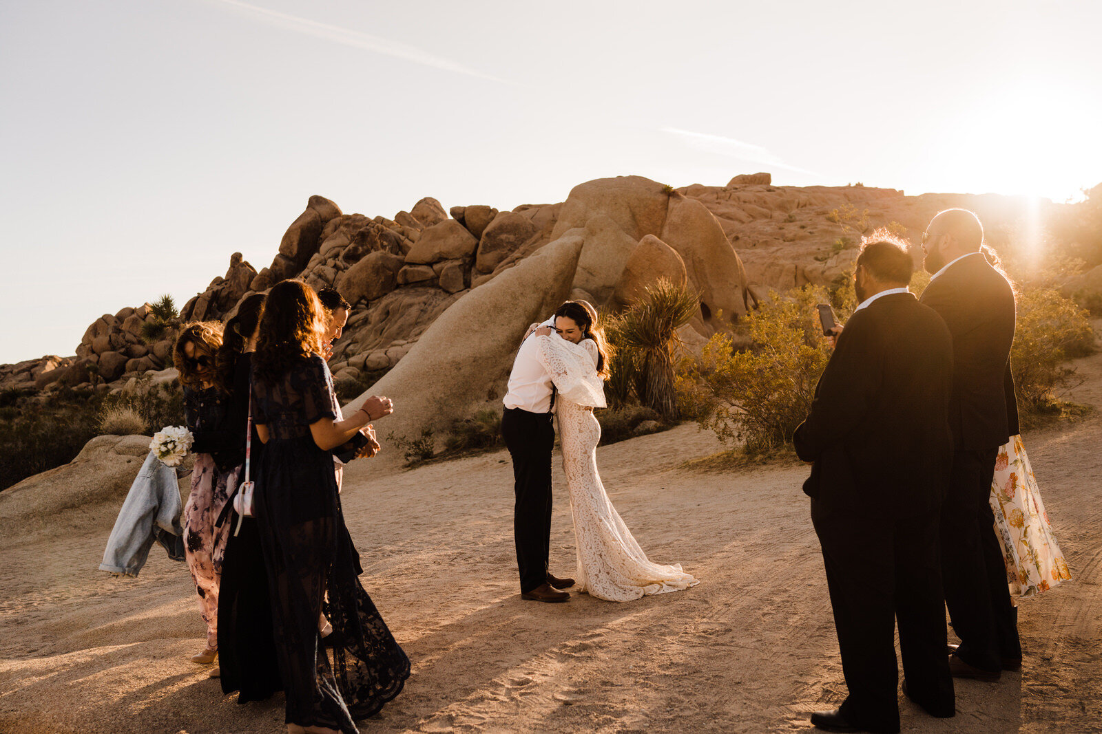 Bride and groom hug after elopement ceremony at Live Oak picnic area in Joshua Tree National park | adventurous, fun, warm wedding photos by Kept Record | www.keptrecord.com