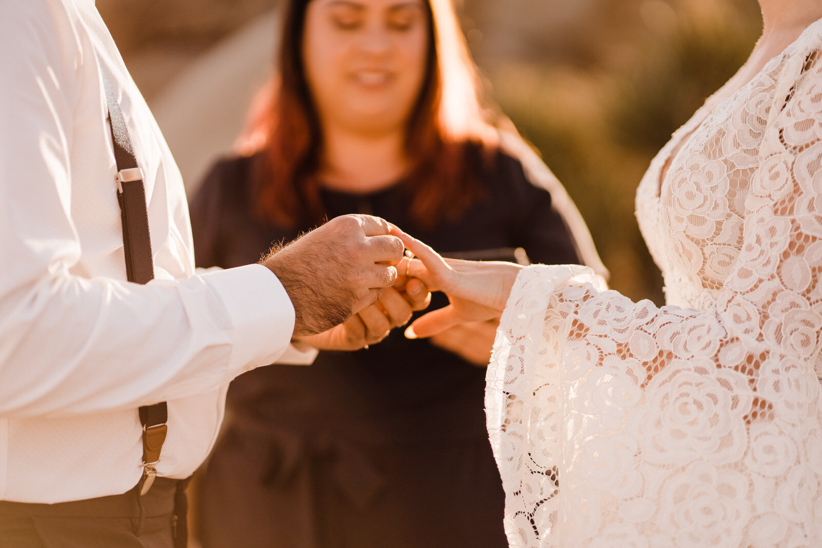 Groom places ring on bride's finger during elopement ceremony in Joshua Tree National Park | adventurous, fun, warm wedding photos by Kept Record | www.keptrecord.com