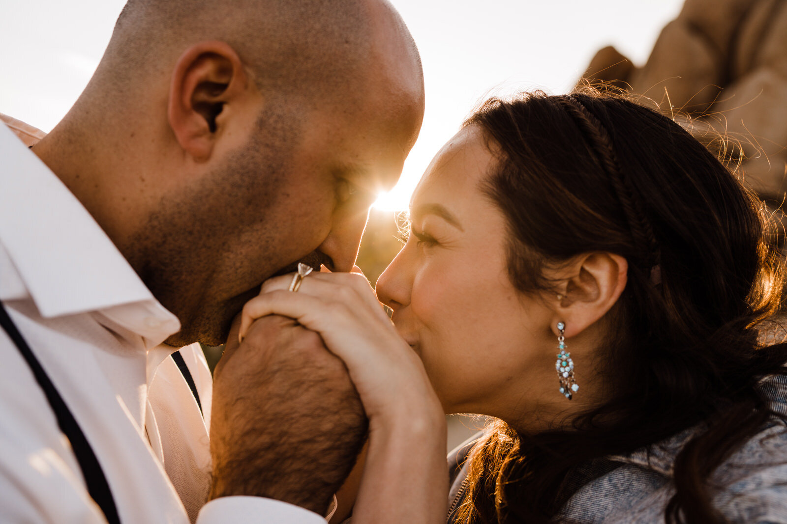 Bride and groom kiss each others hands at Joshua Tree elopement | adventurous, fun, warm wedding photos by Kept Record | www.keptrecord.com