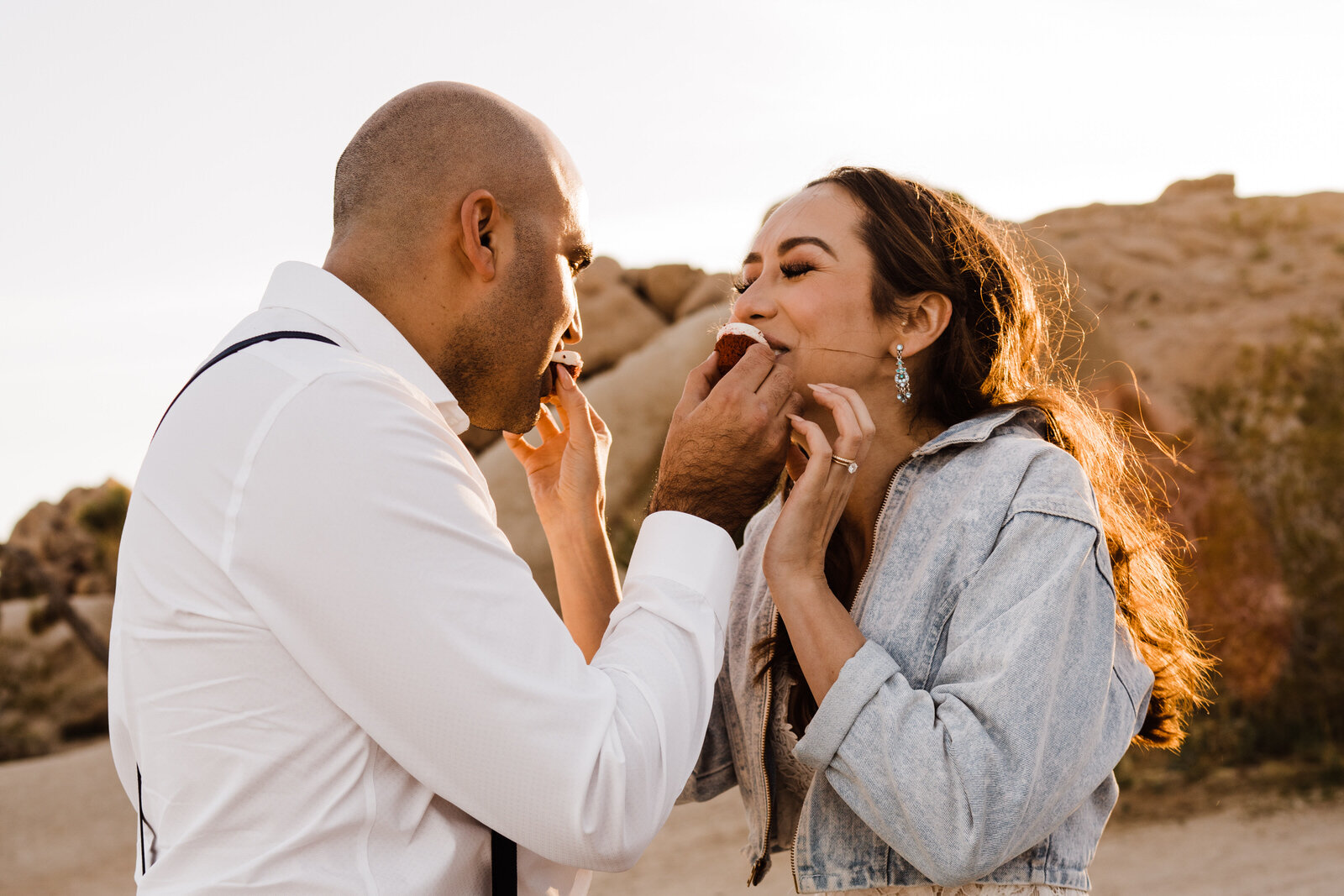 Joshua Tree elopement couple eating red velvet cupcakes to celebrate! | adventurous, fun, warm wedding photos by Kept Record | www.keptrecord.com