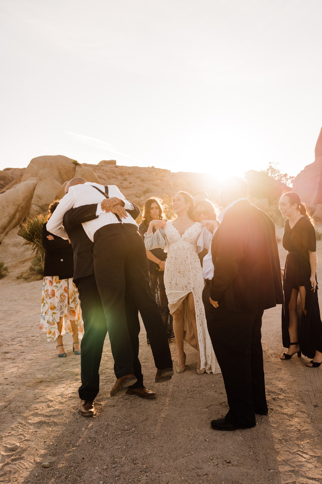 brother lifts groom in hug after elopement ceremony in Joshua Tree National Park | adventurous, fun, warm wedding photos by Kept Record | www.keptrecord.com
