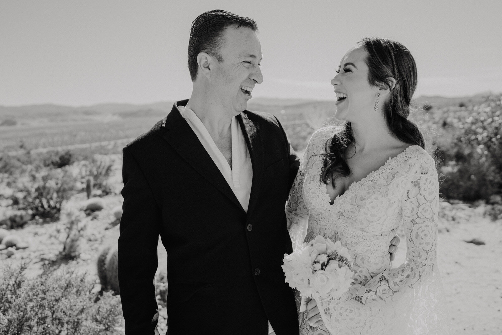 Black and white photo of bride and father of the bride laughing at Cactus Mountain Retreat in Joshua Tree | adventurous, fun, warm wedding photos by Kept Record | www.keptrecord.com