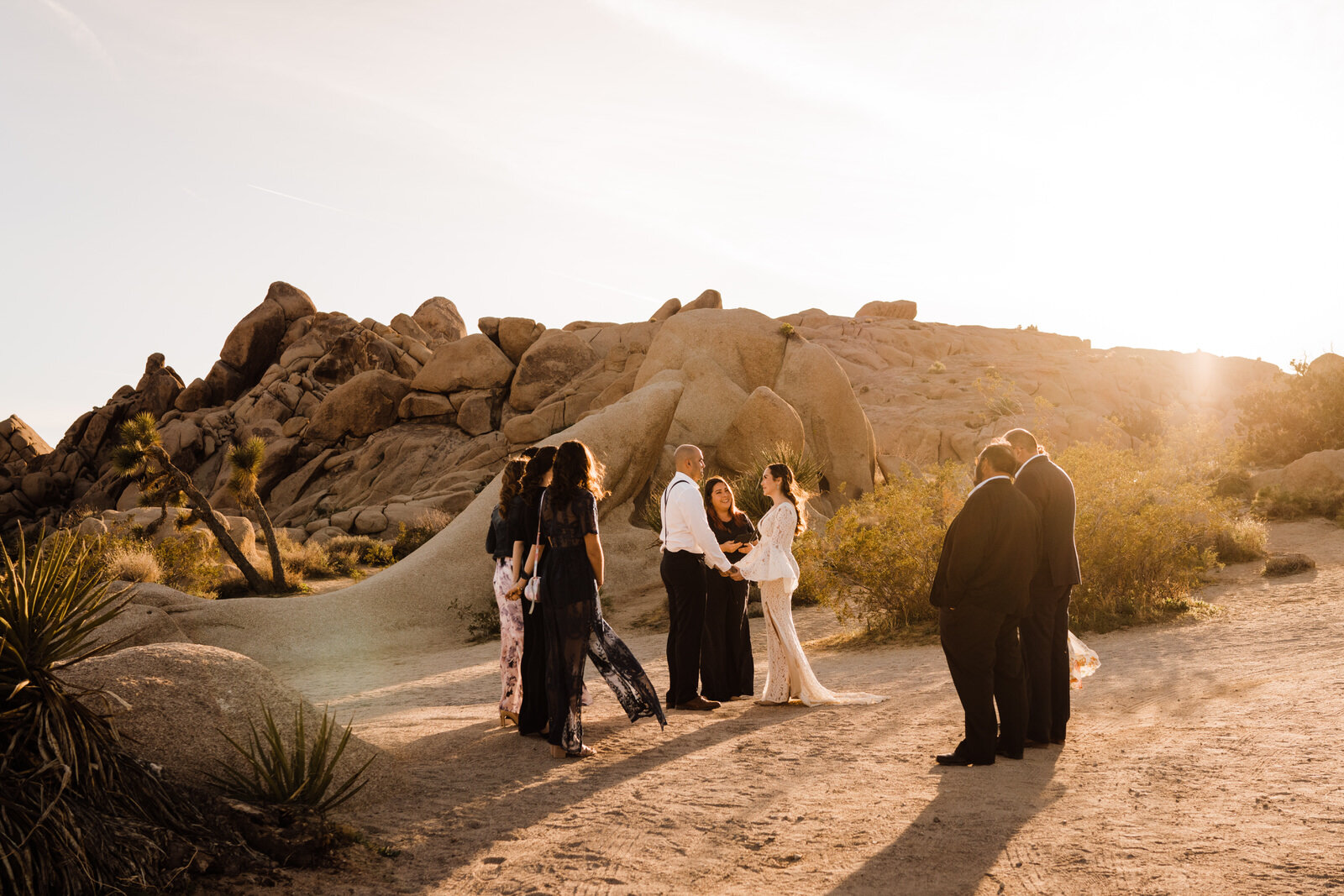 Family gathered around eloping couple at Live Oak Picnic Area in Joshua Tree National Park | adventurous, fun, warm wedding photos by Kept Record | www.keptrecord.com