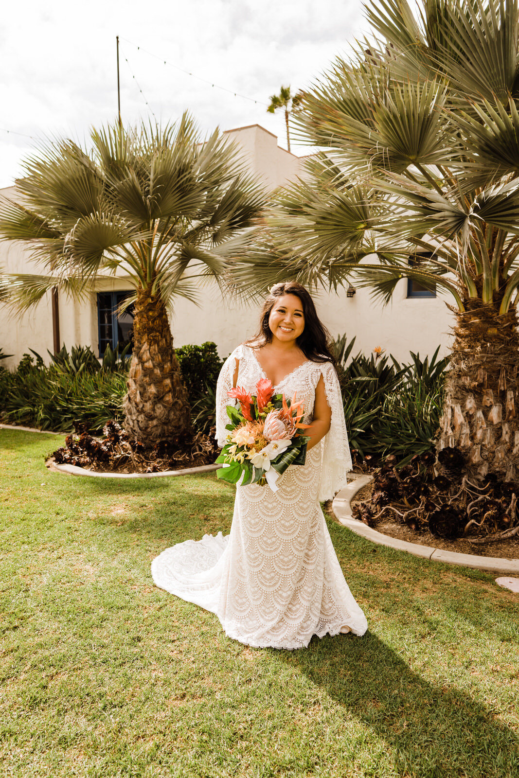 Bride in bohemian dress at Ole Hanson Beach Club with tropical bouquet from Island Leis and Bouquets