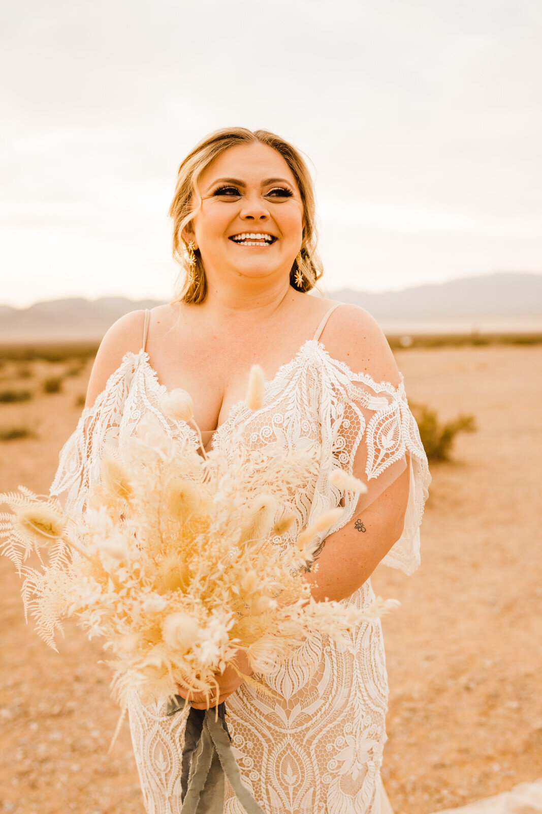 Bride smiles at sunrise first look at Seven Magic Mountains in Las Vegas desert