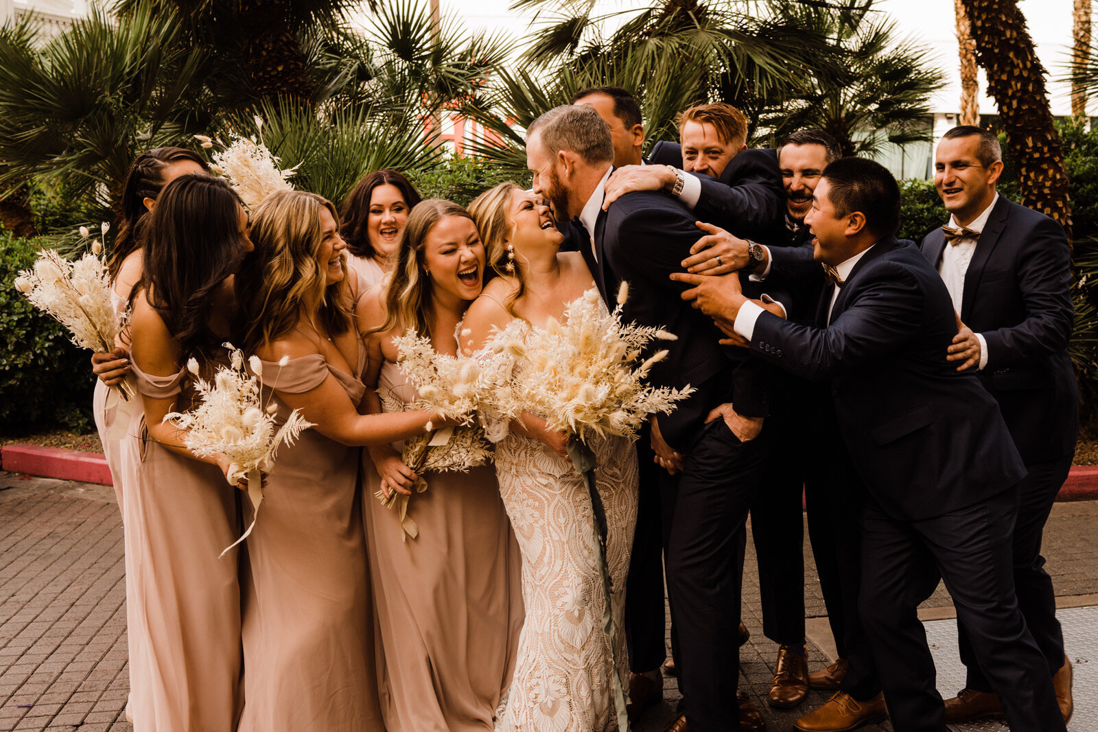 Fun, Energetic Destination Wedding Bridal Party in Las Vegas, Nevada at The Flamingo Casino hugging bride and groom