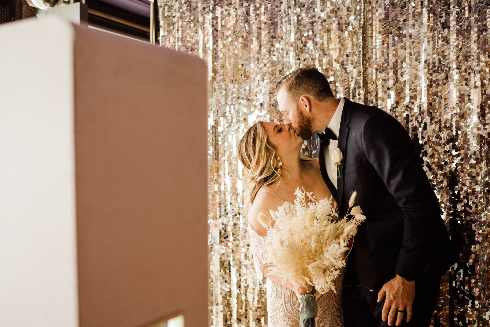 Bride and Groom in photobooth with pampas grass bouquet in Las Vegas wedding reception at Margaritaville