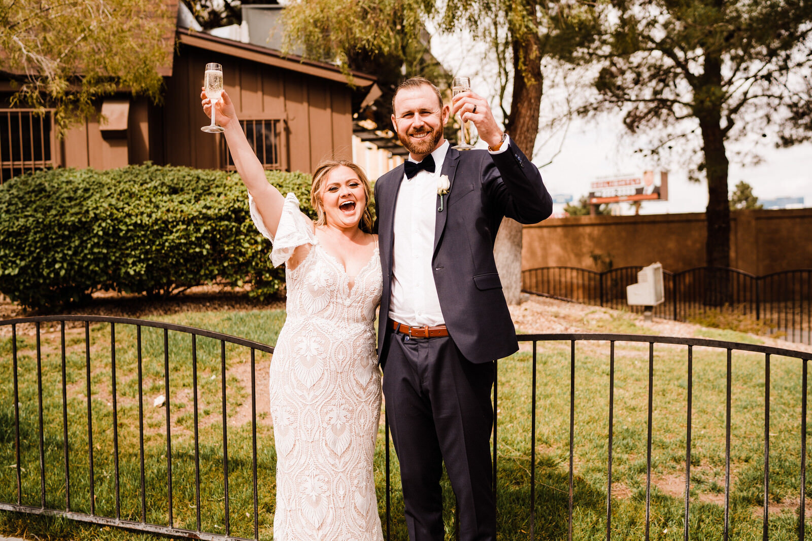 Bride and groom cheer with champagne outside Little Church of the West Wedding Chapel in Las Vegas,NV