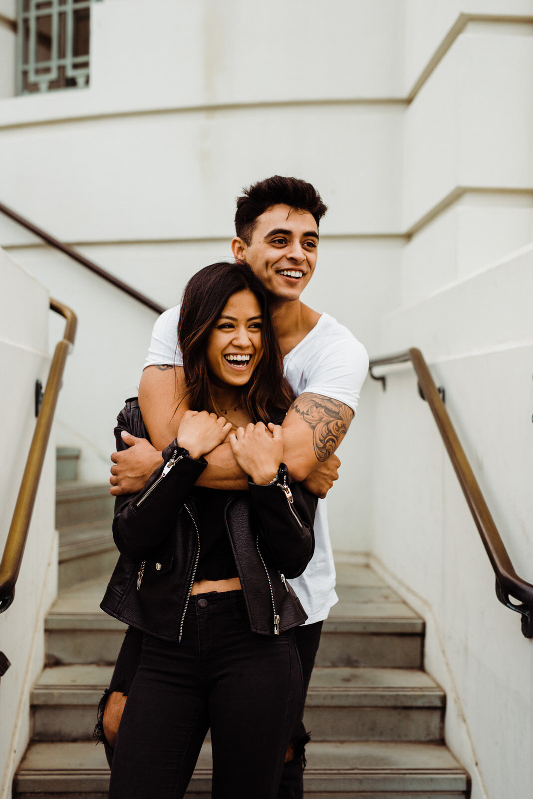 Couple hugging at Griffith Observatory engagement shoot, Indian-Filipino tattooed couple, black and white engagement outfits, edgy engagement shoot