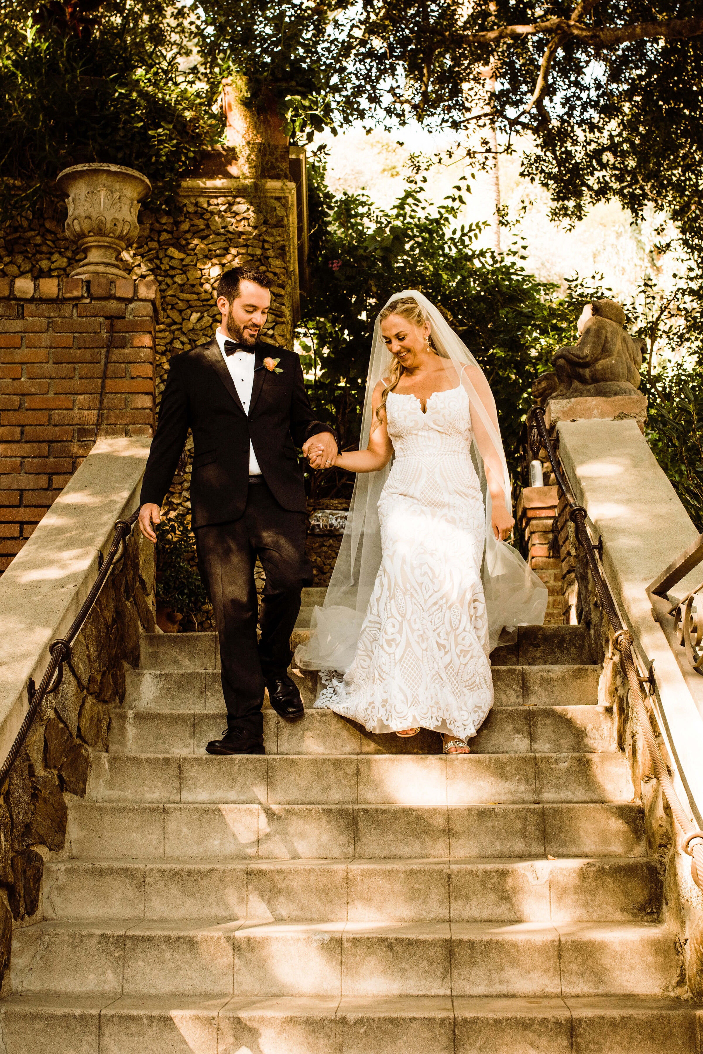 Houdini Estate Wedding - Bride in Hayley Paige Blush Dress and Groom in Black Tux on Garden Terrace - Historic Los Angeles Wedding Venue | Candid Photo by Kept Record | www.keptrecord.com