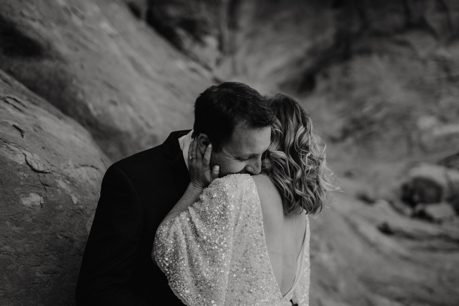 Arches-National-Park-Wedding-groom-romantically-kissing-bride-at-double-arches (3).jpg