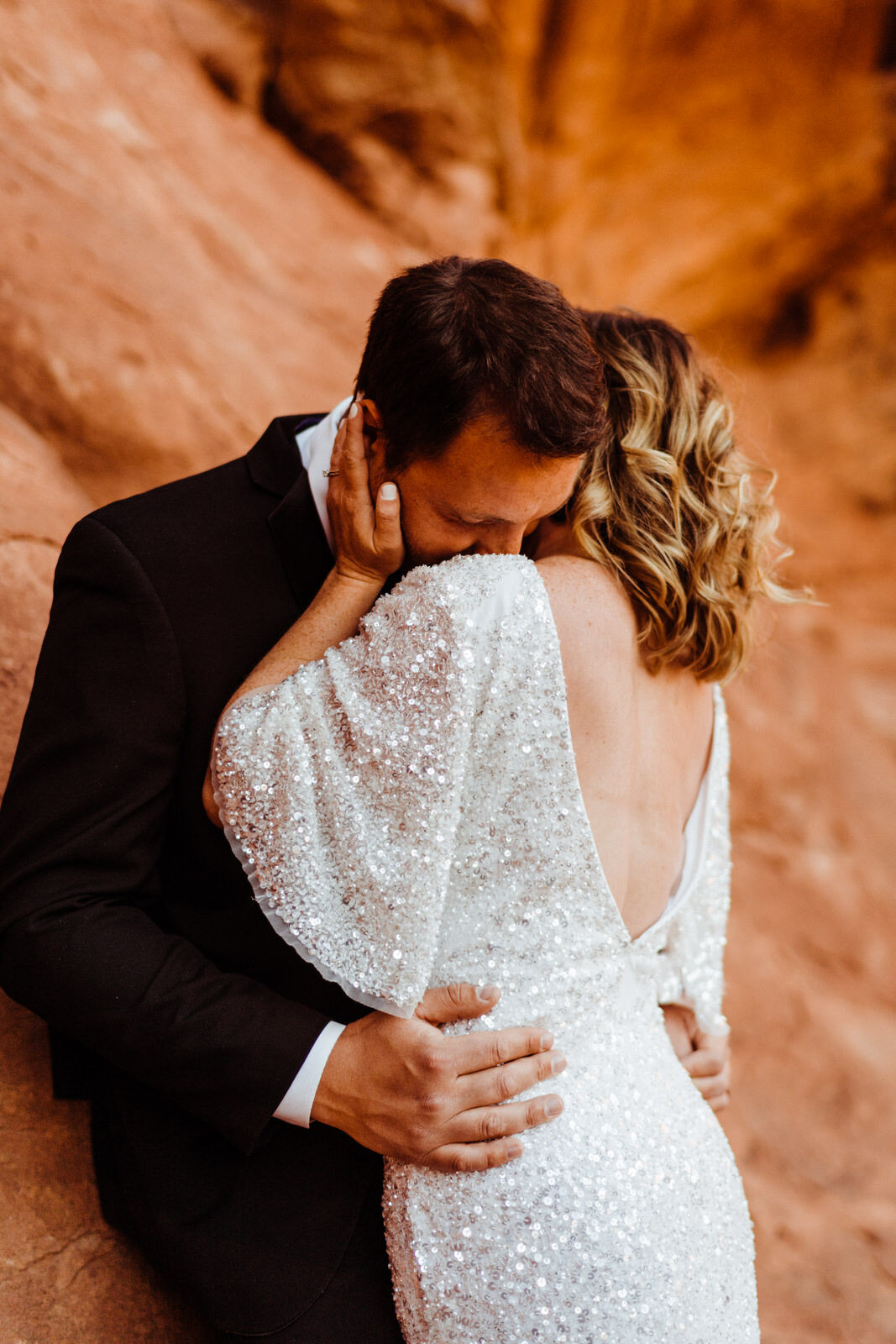 Arches-National-Park-Wedding-groom-romantically-kissing-bride-at-double-arches (1).jpg