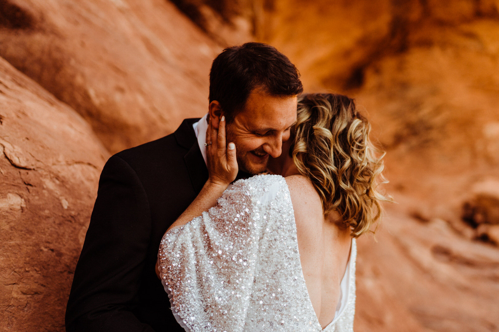 Arches-National-Park-Wedding-groom-romantically-kissing-bride-at-double-arches (2).jpg