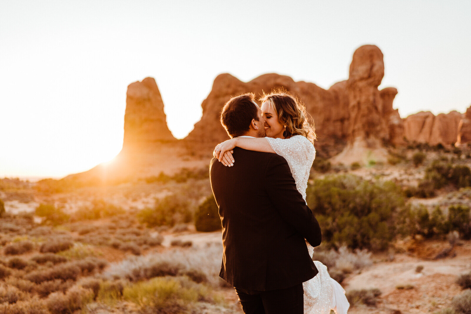 Arches-National-Park-Wedding-groom-lifts-bride-and-spins.jpg
