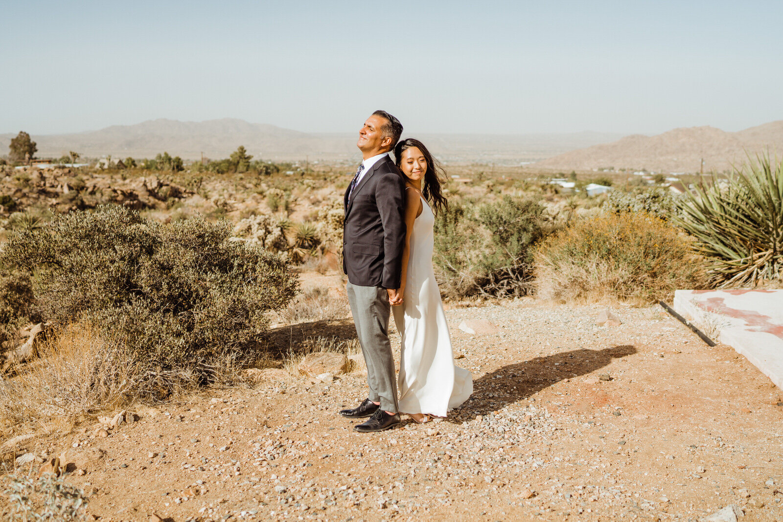 Bride and groom Stand back to back before first look at Joshua Tree wedding