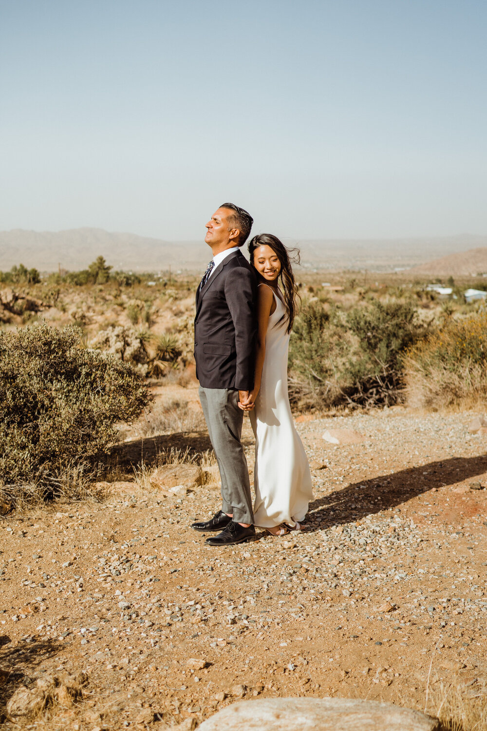 Bride Peeks over Shoulder at Groom before First Look in Joshua Tree