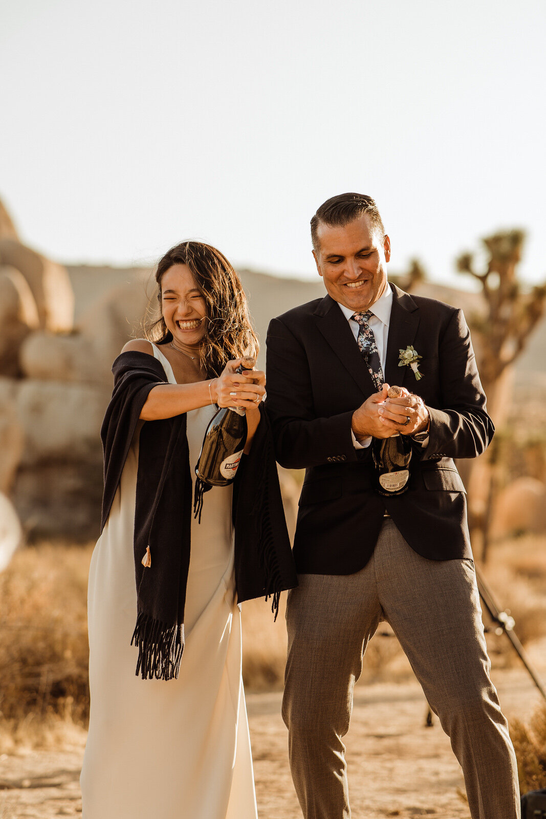 Bride and Groom Struggle to Open Champagne Bottle in Joshua Tree