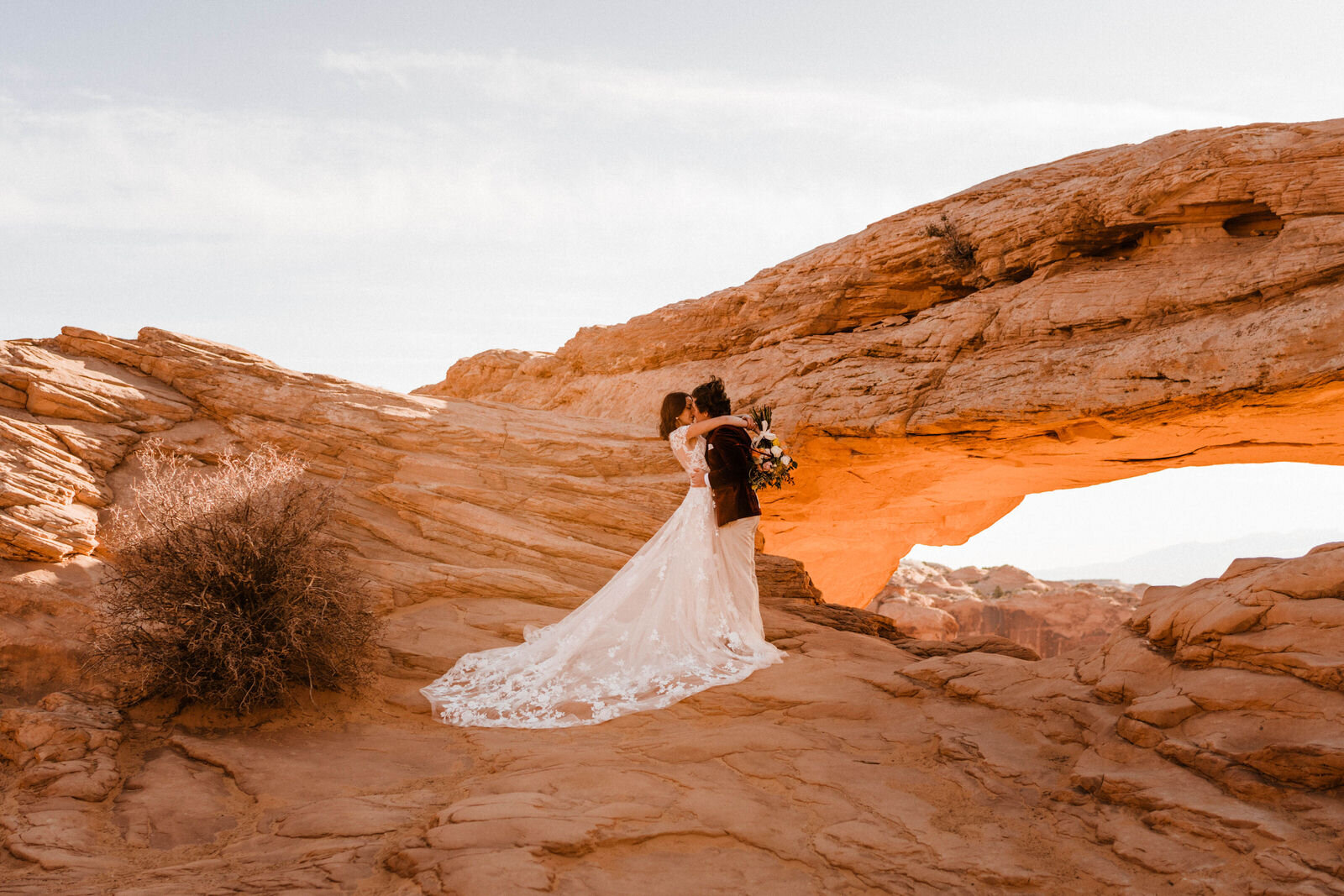 Bride and Groom at Canyonlands Mesa Arch | Groom in Red Velvet Suit | Moab Wedding Photographer Kept Record | www.keptrecord.com