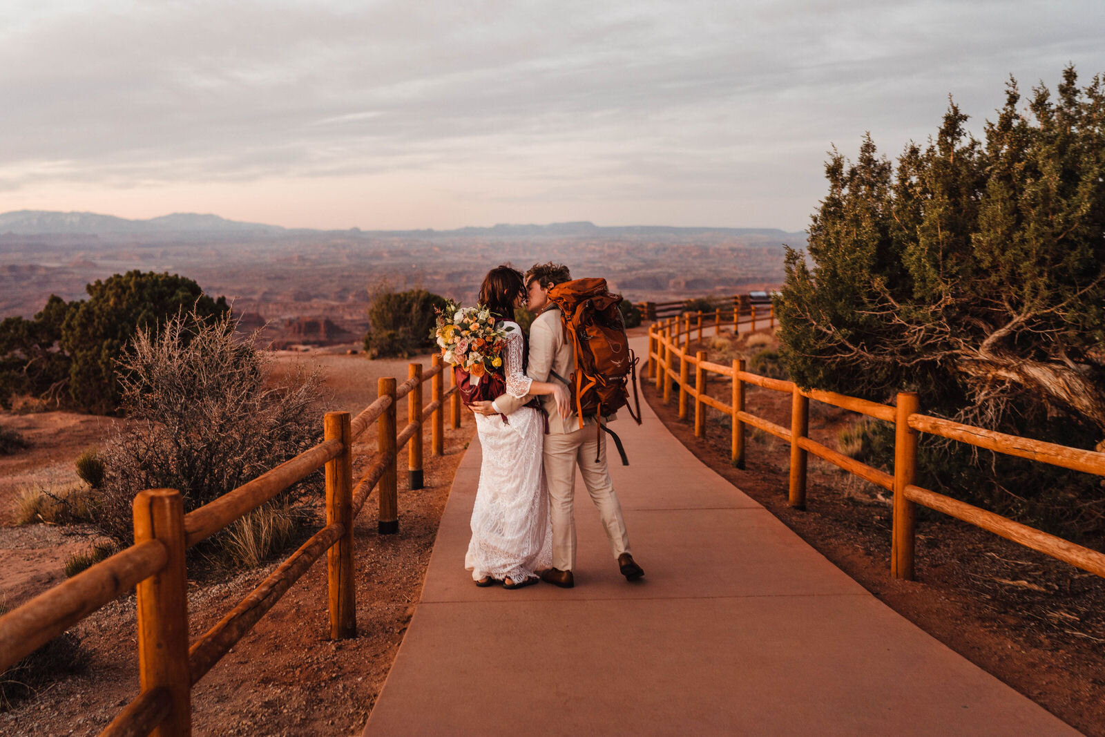 Hiking Bride and Groom with Osprey Packs at Canyonlands Island in the Sky | Moab Wedding Photographer Kept Record | www.keptrecord.com