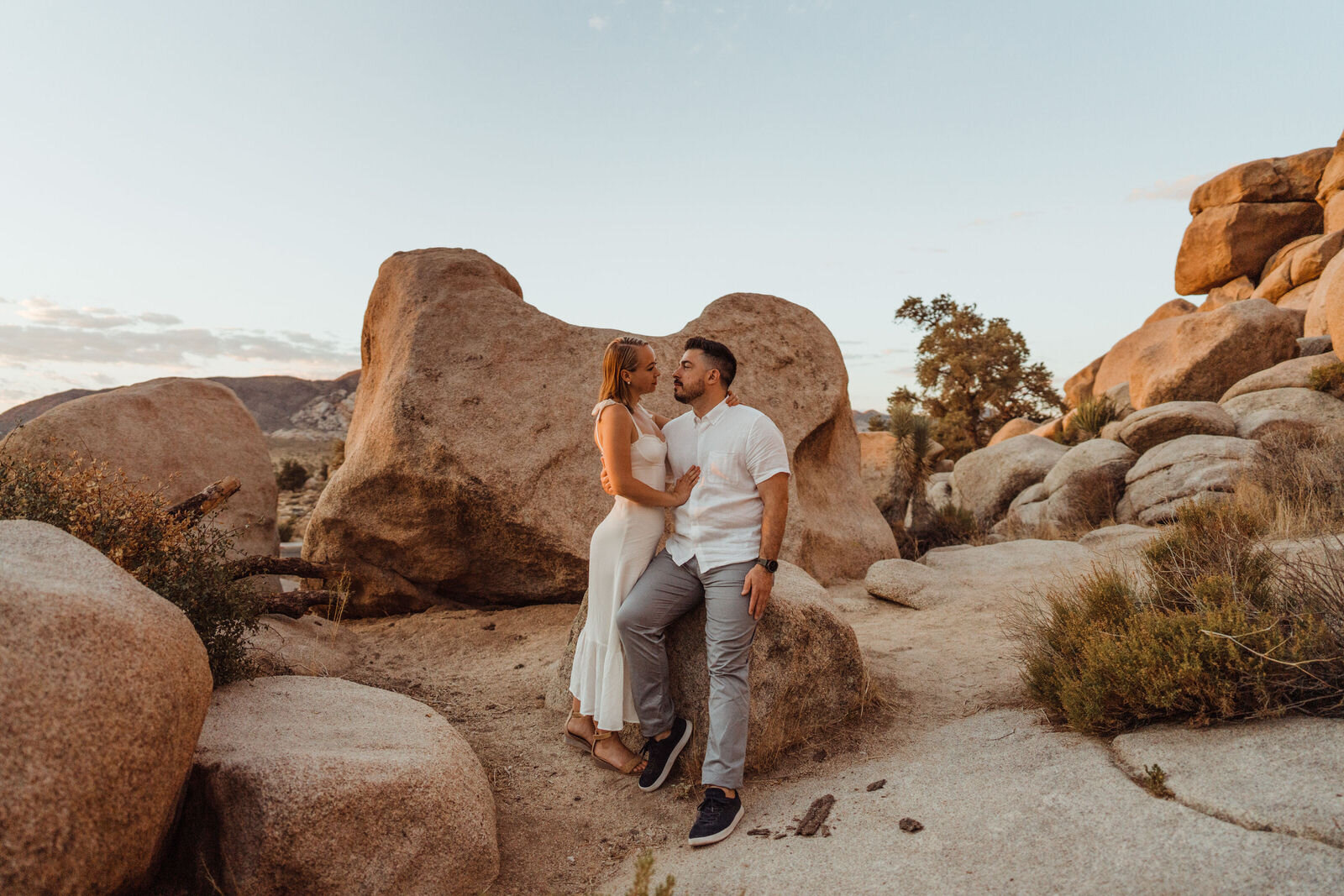 Couple surrounded by Boulders in Joshua Tree at Sunrise Summer Engagement Session - photos by adventurous Joshua Tree elopement photographer Kept Record | www.keptrecord.com