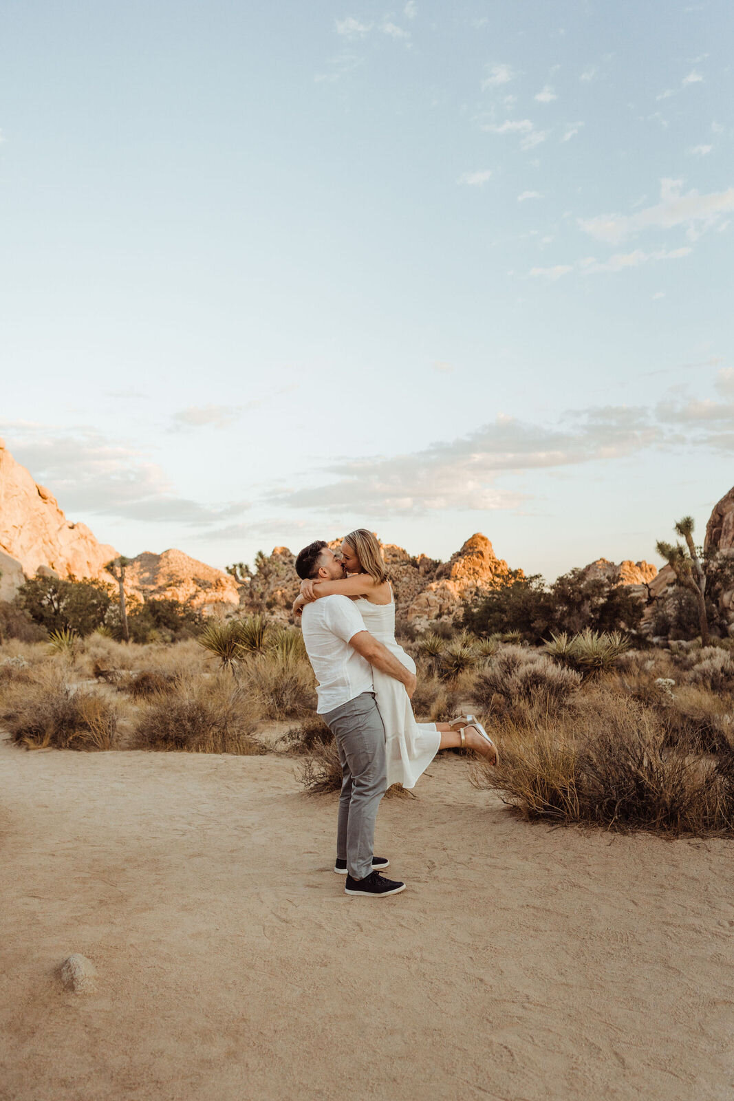 Man Lifts Fiancee in Joshua Tree at Sunrise Summer Engagement Session - photos by adventurous Joshua Tree elopement photographer Kept Record | www.keptrecord.com