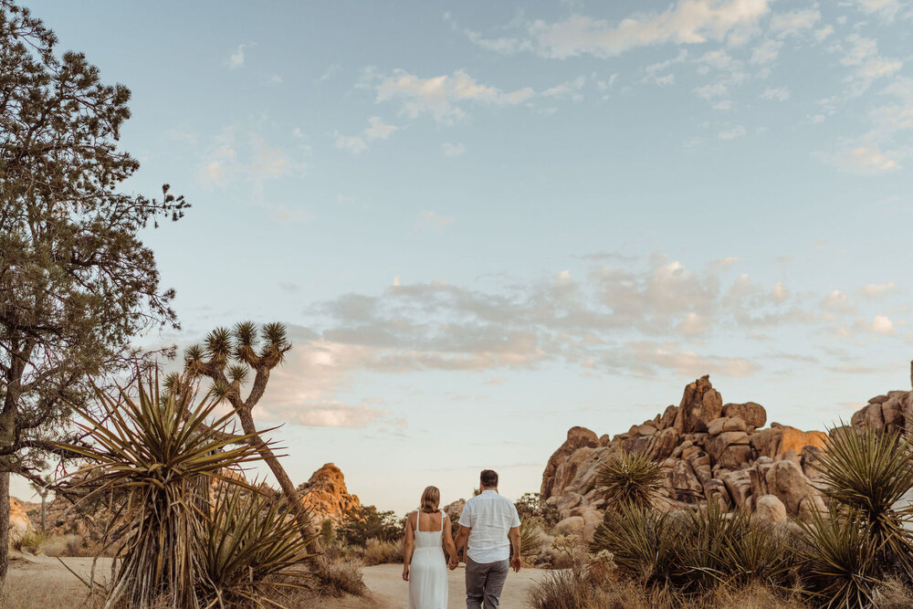 Couple walks into Valley at Joshua Tree at Sunrise Summer Engagement Session - photos by adventurous Joshua Tree elopement photographer Kept Record | www.keptrecord.com