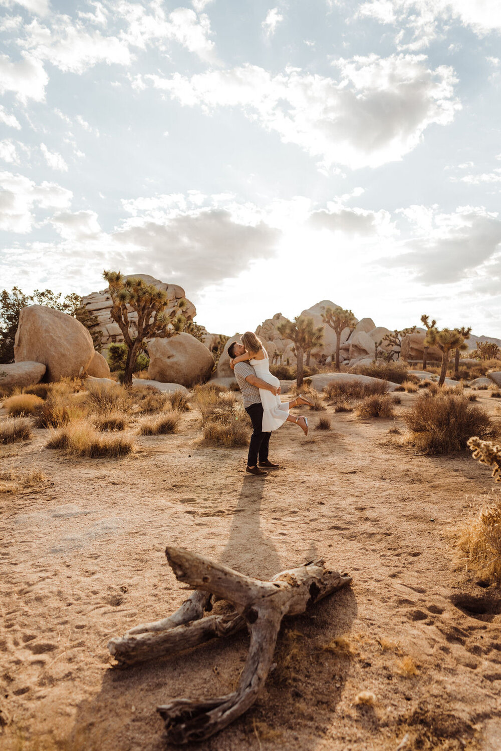 Man Lifts Fiancee Sunrise Session in Joshua Tree - Neutral Engagement Outfits - Fun Engagement Photos by adventurous Joshua Tree Wedding and Elopement Photographer Kept Record | www.keptrecord.com