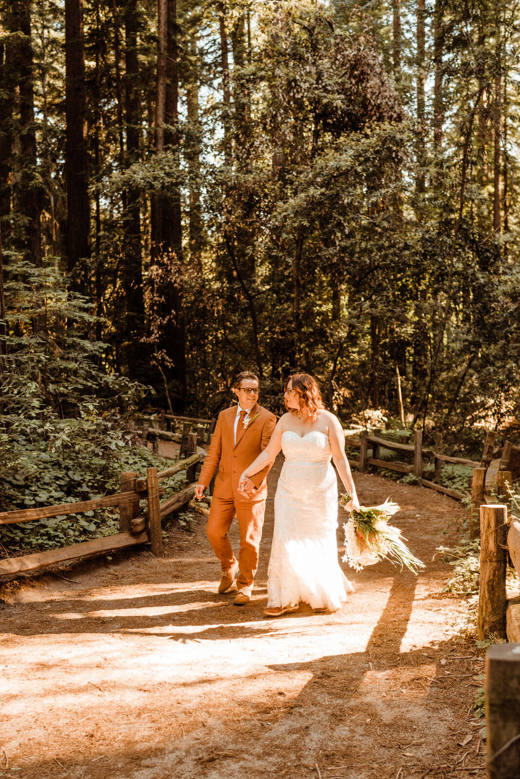 Henry-Cowell-Redwoods-State-Park-Wedding-Santa-Cruz-Groom-in-Rust-Orange-Suit-and-Bride-beneath-Trees.jpg